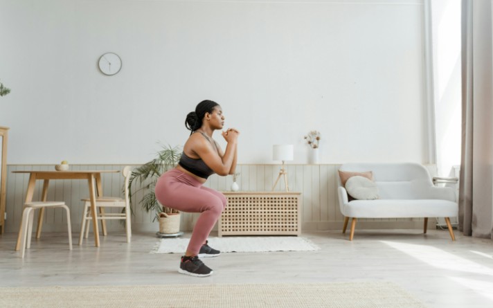 woman doing squats in living room
